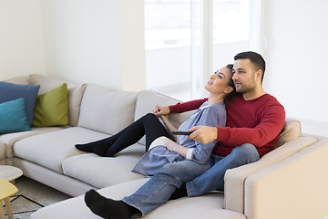 Image showing Young couple on the sofa watching television