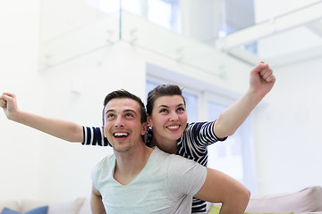 Image showing handsome man piggybacking his girlfriend