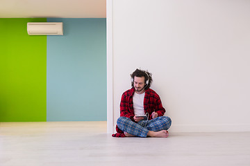 Image showing young man enjoying music through headphones