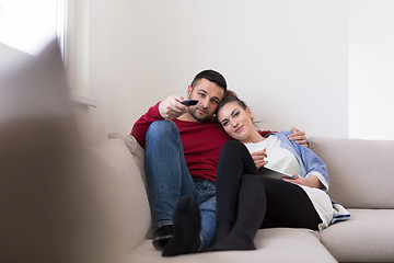 Image showing Young couple on the sofa watching television