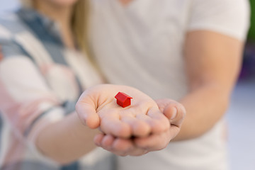 Image showing couple showing small red house in hands