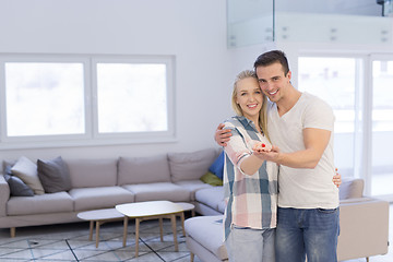 Image showing couple showing small red house in hands