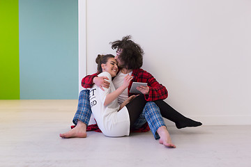 Image showing Young Couple using digital tablet on the floor