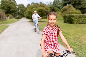 Image showing grandmother and granddaughter cycling at park