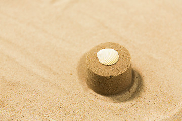 Image showing sand shape made by mold with shell on summer beach