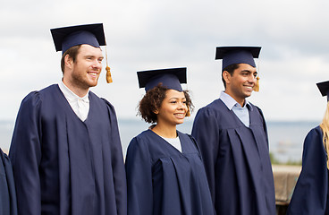 Image showing happy students or bachelors in mortar boards