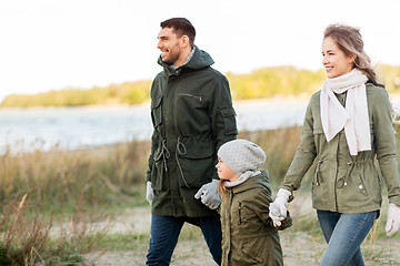 Image showing happy family walking along autumn beach