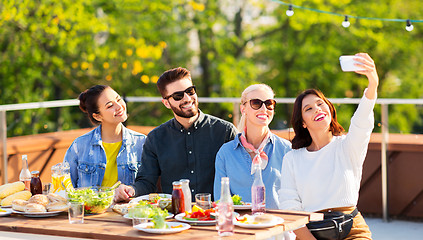 Image showing happy friends taking selfie at rooftop party