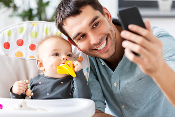 Image showing father with baby daughter taking selfie at home