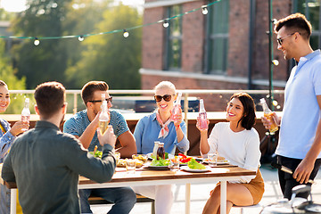 Image showing happy friends with drinks or bbq party on rooftop