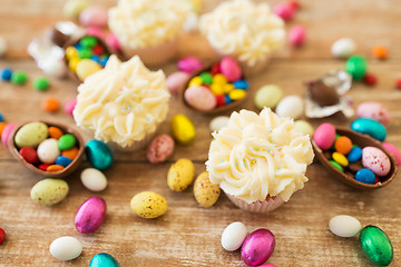 Image showing cupcakes with chocolate eggs and candies on table