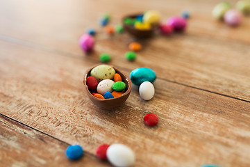 Image showing chocolate egg and candy drops on wooden table