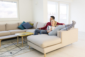 Image showing Young couple on the sofa watching television