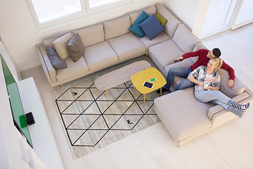 Image showing Young couple on the sofa watching television