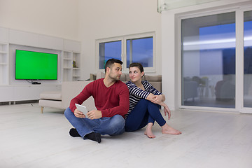 Image showing Young Couple using digital tablet on the floor