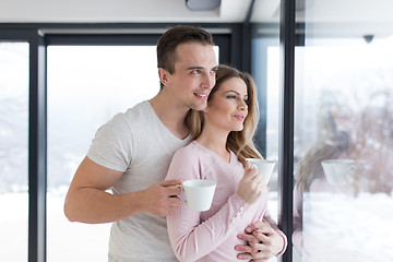 Image showing young couple enjoying morning coffee by the window