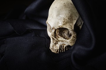 Image showing Closeup photo an old skull covered in black robe