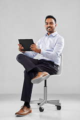 Image showing indian businessman with tablet pc on office chair