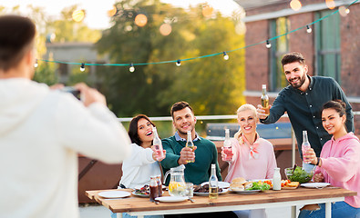 Image showing happy friends photographing at rooftop party