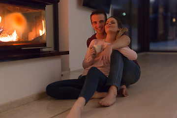 Image showing happy couple in front of fireplace