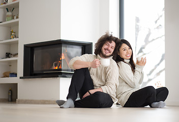 Image showing happy multiethnic couple  in front of fireplace