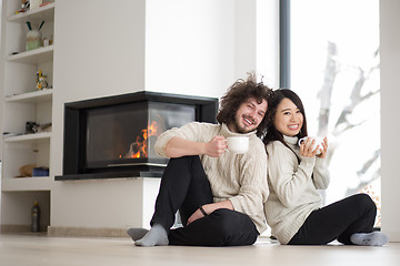 Image showing happy multiethnic couple  in front of fireplace