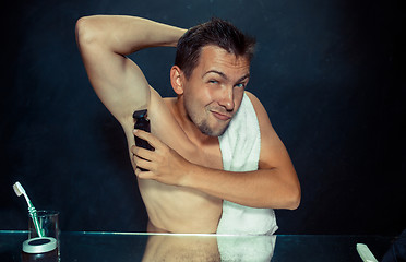 Image showing Photo of handsome man shaving his armpit