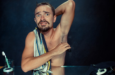 Image showing Photo of handsome man shaving his armpit