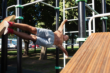 Image showing Athlete doing exercises at stadium at park