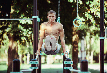 Image showing Athlete doing exercises at stadium at park