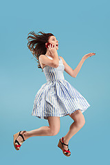 Image showing Full length of pretty young woman with mobile phone while jumping