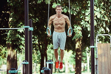 Image showing Athlete doing exercises at stadium at park