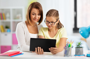 Image showing mother and daughter with tablet pc doing homework