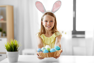 Image showing happy girl with colored easter eggs at home