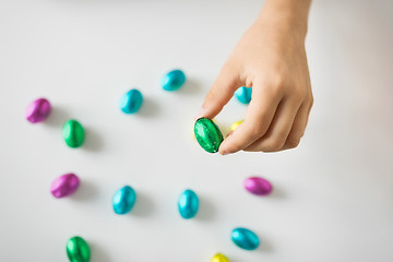 Image showing hand of child with chocolate easter eggs in foil