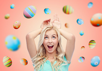 Image showing happy smiling young woman making easter bunny ears