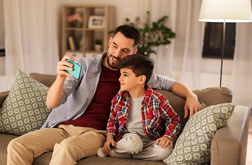 Image showing father and son taking selfie at home