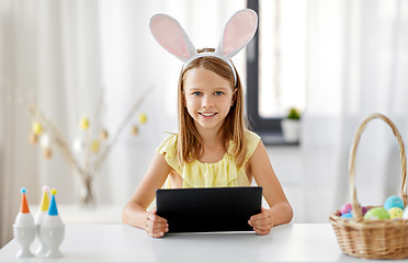 Image showing happy girl with tablet pc and easter eggs at home