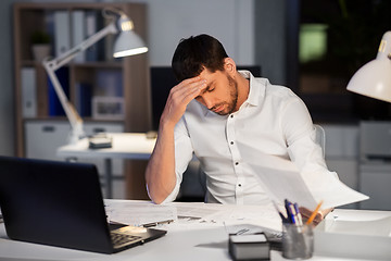 Image showing businessman with papers working at night office