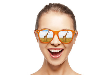 Image showing happy teen girl in sunglasses looking at giraffes