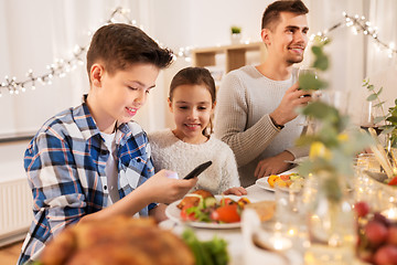 Image showing children with smartphone at family dinner party