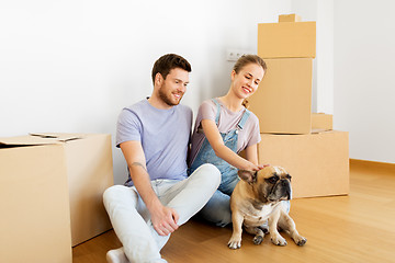 Image showing happy couple with boxes and dog moving to new home