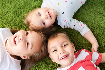 Image showing happy little kids lying on floor or carpet