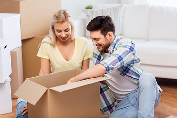 Image showing happy couple unpacking boxes at new home