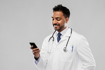 Image showing smiling indian male doctor with smartphone