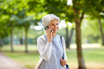 Image showing senior woman calling on smartphone in summer park