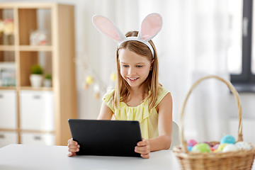 Image showing happy girl with tablet pc and easter eggs at home