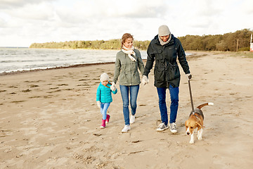 Image showing happy family walking with beagle dog on beach