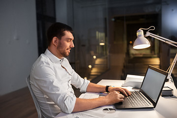 Image showing businessman with laptop working at night office