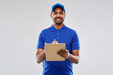 Image showing happy indian delivery man with clipboard in blue